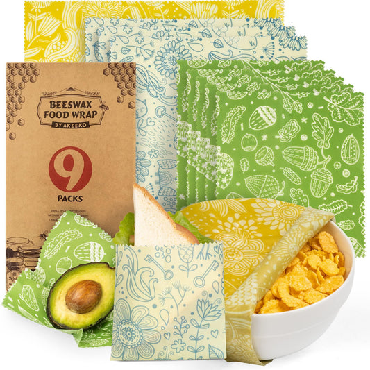 Colorful beeswax food wraps with floral prints covering sandwich, avocado, and bowl of cereal