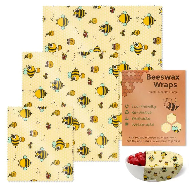 Three square reusable beeswax food wraps featuring a yellow bee pattern for plastic-free kitchen storage.