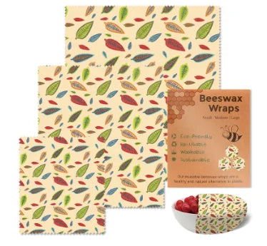 Multicolor leaf pattern reusable beeswax food wrap for plastic-free kitchen storage with packaging and a bowl.