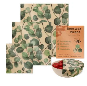 Reusable beeswax food wrap sheets with green eucalyptus pattern for plastic-free kitchen storage.