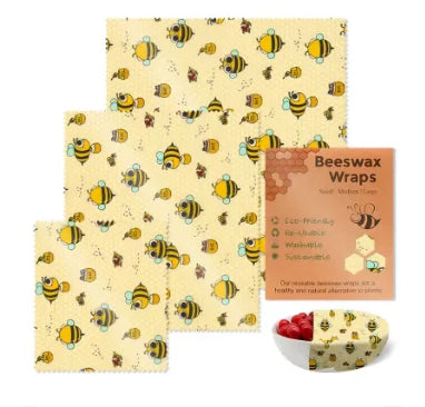 Yellow reusable beeswax food wrap with a bee pattern, used for plastic-free kitchen storage, with packaging and a bowl.