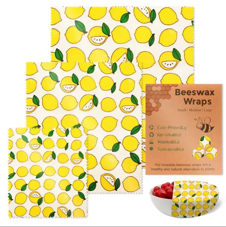 Three reusable beeswax food wrap sheets with yellow lemon patterns, ideal for plastic-free kitchen storage.