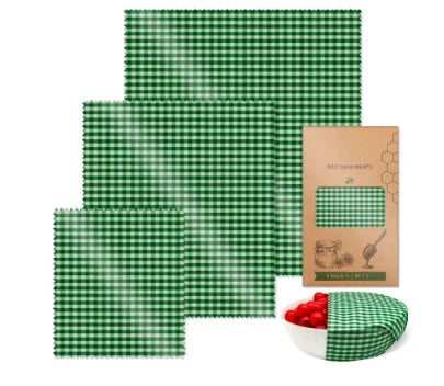 Green and white checkered reusable beeswax food wrap sheets and packaging for plastic-free kitchen storage.