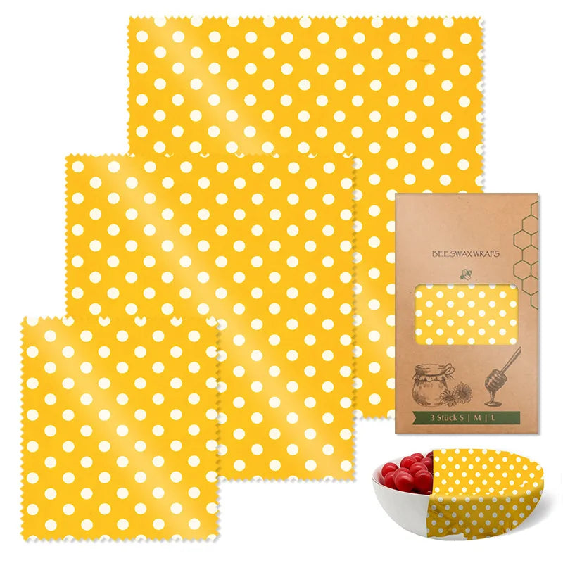 Yellow polka dot reusable beeswax food wrap set for plastic-free kitchen storage with a packaged box and a covered bowl.