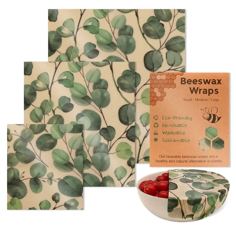 Reusable beeswax food wrap set with green eucalyptus leaf pattern on beige, ideal for plastic-free kitchen storage.
