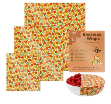 Reusable beeswax food wrap in orange citrus print for plastic-free kitchen storage, shown in multiple sizes with a bowl.