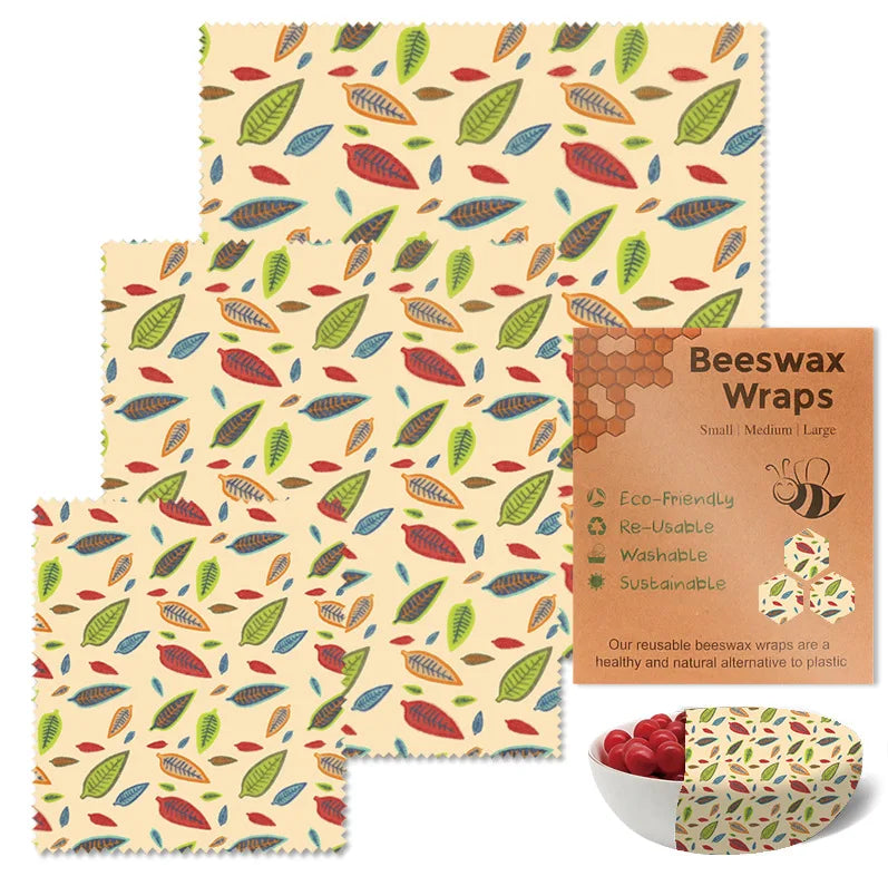 Three reusable beeswax food wrap sheets featuring a colorful leaf pattern for plastic-free kitchen storage.